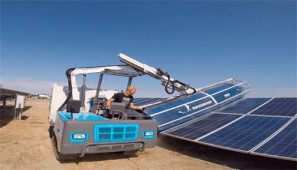صورة تبين عامل يقوم بتنظيف الألواح الشمسية باستخدام ألة تنظيف مركبة على شاحنة