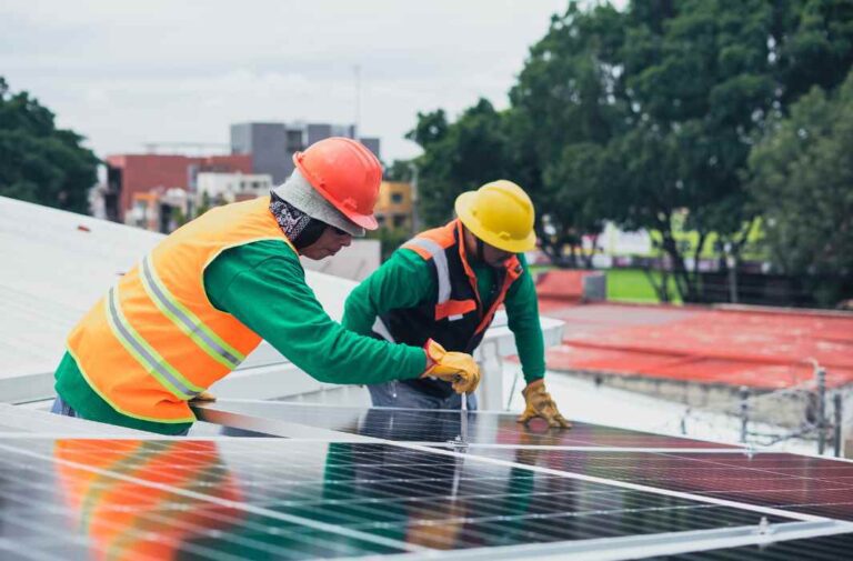عمال يقومون بتثبيت الألواح الشمسية في المحطة