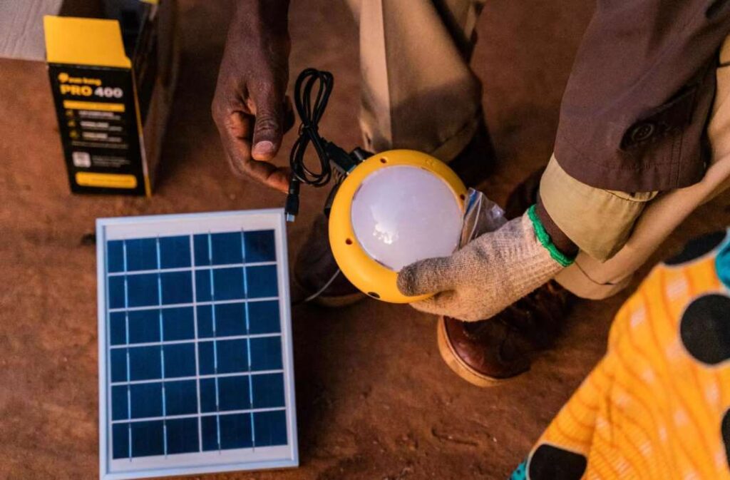 رائد أعمال في مجال الطاقة الشمسية مع مصباح SKP 400 في زامبيا، 2024. © SolarAid
